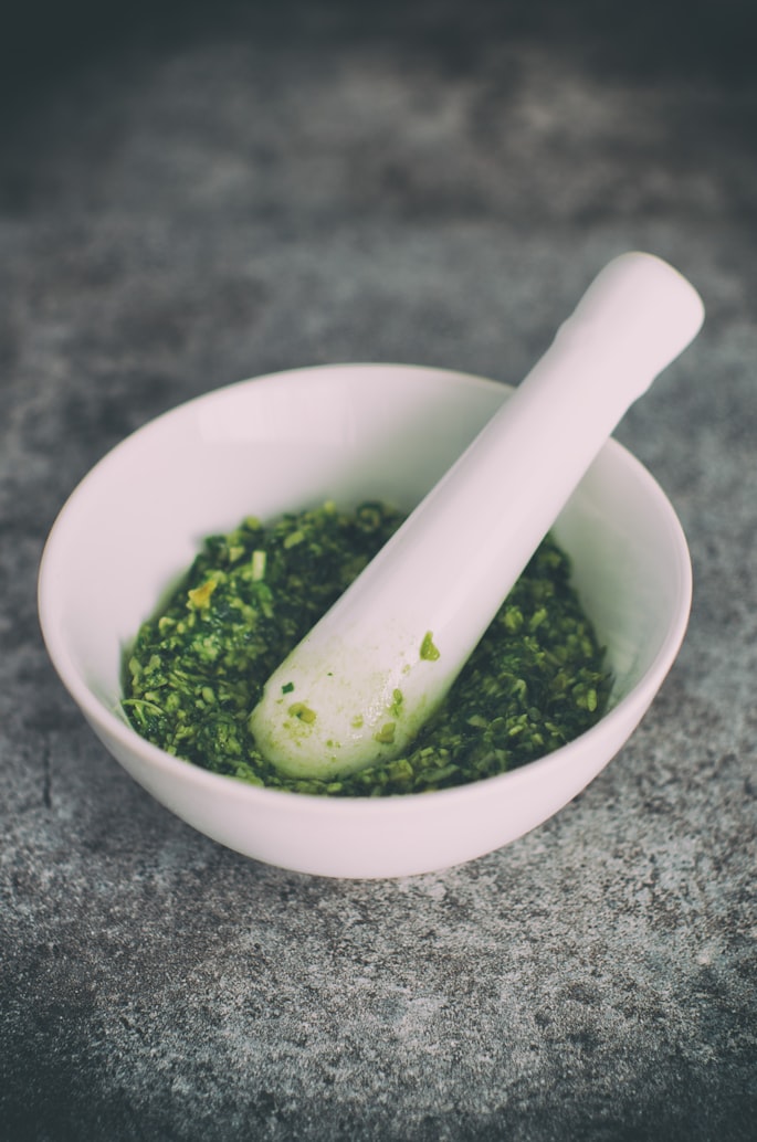 Grüne Kräuterpaste im Mörser – frisch blanchierte Brennnesseln zu einer samtigen Sauce verarbeitet