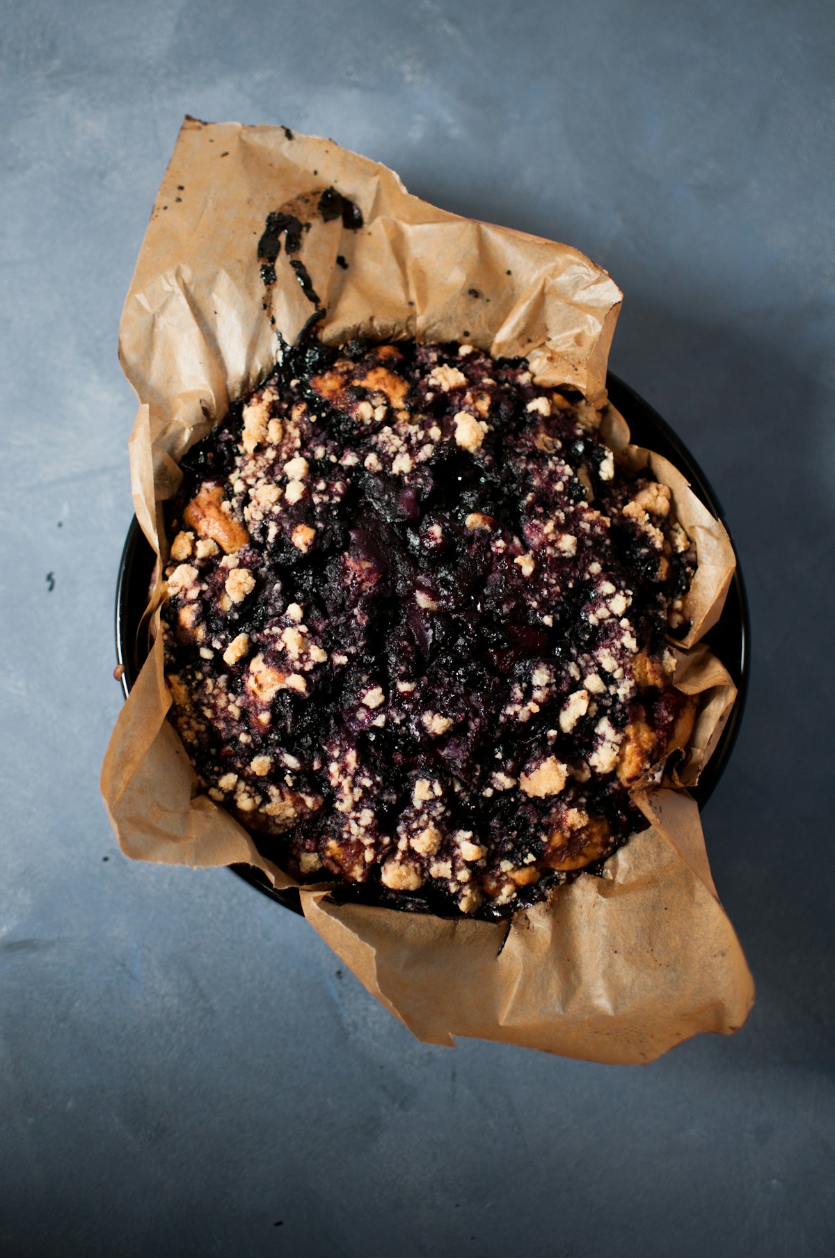 Beerenkuchen mit Streusel in einer runden dunklen Form – Aufsicht, ähnlich wie im Dutch Oven