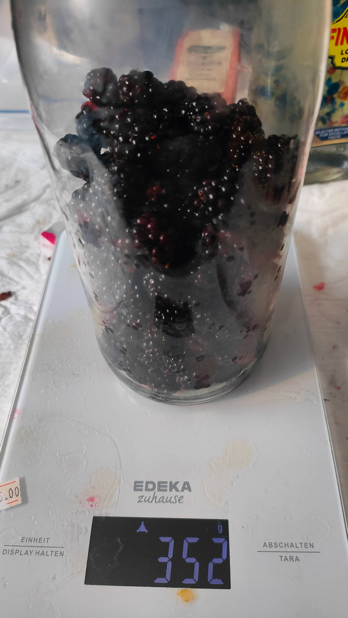 Glas mit Brombeeren auf einer Küchenwaage, Anzeige 352 Gramm