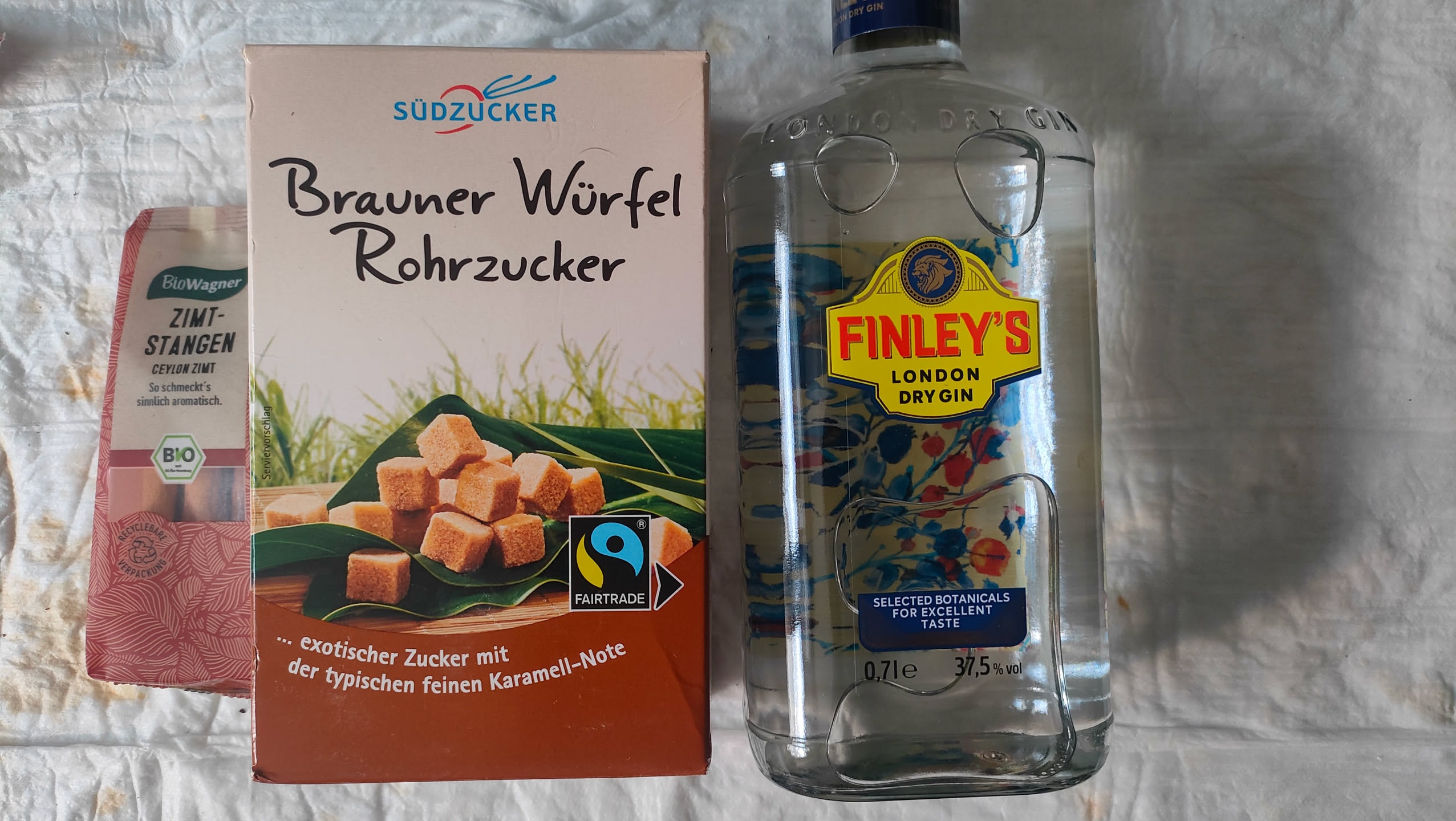 Zutaten für den Ansatz: Zimtstangen, brauner Würfel-Rohrzucker und eine Flasche Finley's London Dry Gin