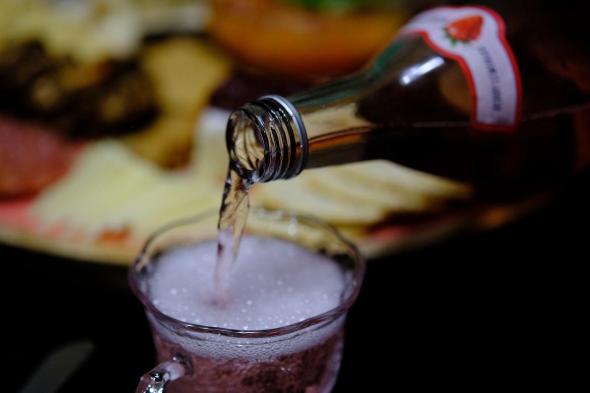 Selbst gemachter Hagebutten-Sirup wird aus einer Flasche eingeschenkt – tiefrot und aromatisch