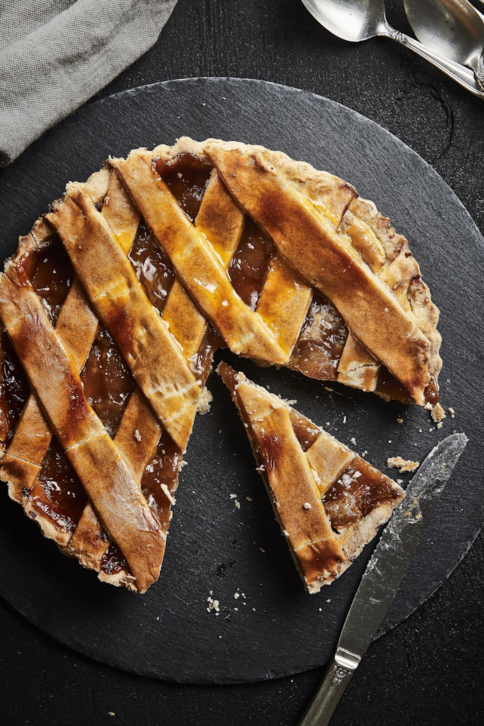Apfelkuchen mit Gitterdeckel auf Schieferplatte