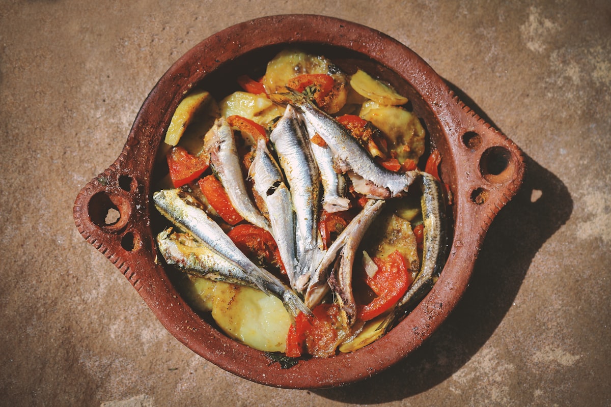 Ganzer Fisch mit Kartoffeln und Tomaten in rustikalem Tonbräter – herzhafter Fischeintopf