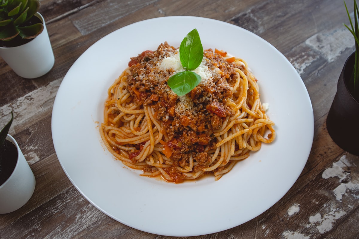 Spaghetti Bolognese mit Hackfleischsauce, geriebenem Parmesan und frischem Basilikum