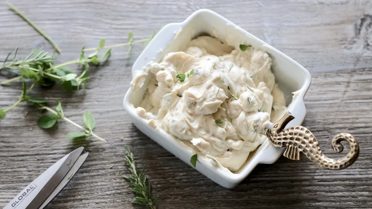 Kräuter-Frischkäse-Aufstrich auf Brot mit frischen grünen Kräutern