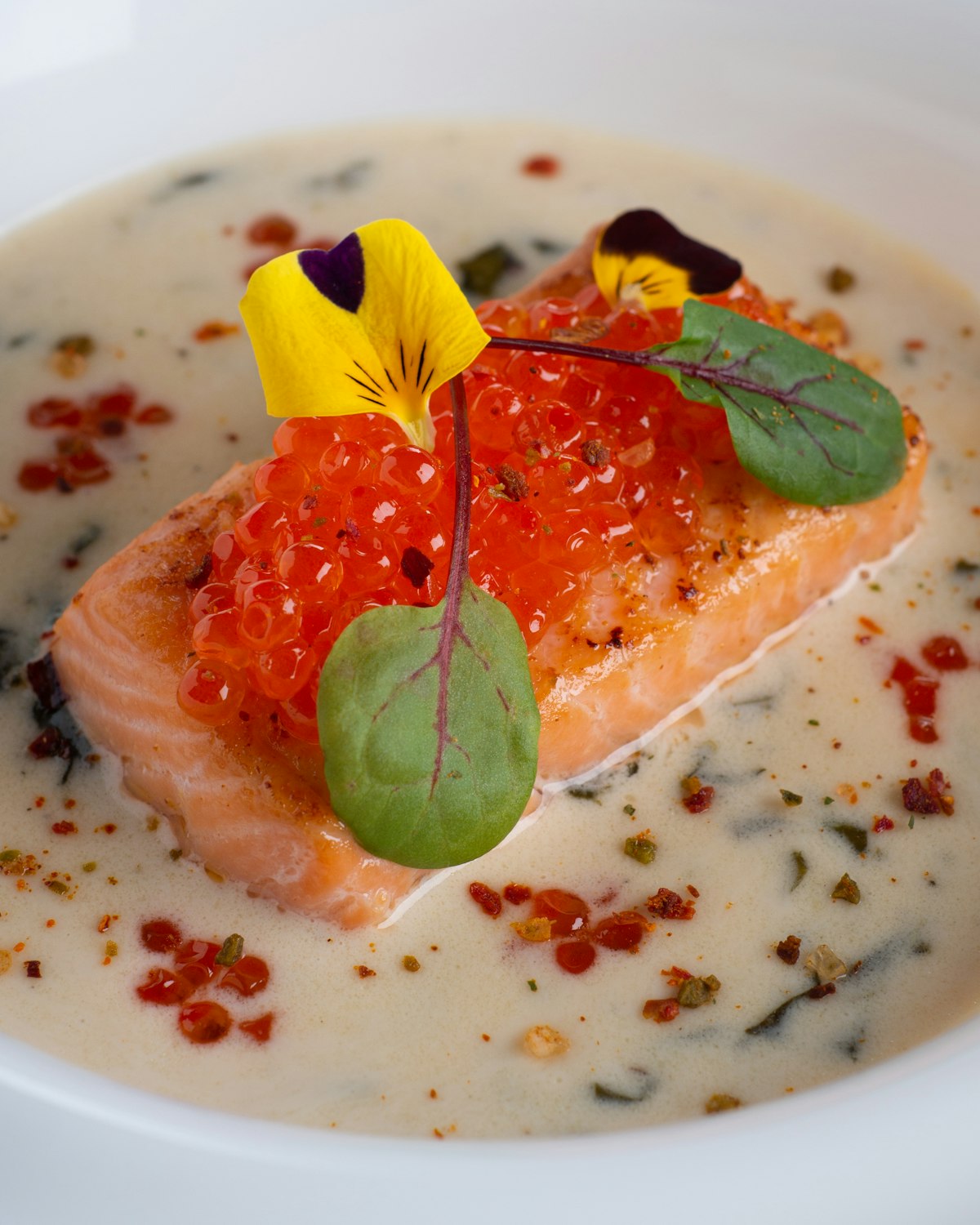 Lachsfilet auf cremiger Kräutersauce mit Sauerampferblättern und essbaren Blüten