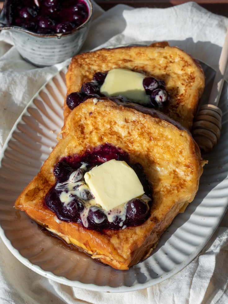 French Toast mit dunklem Kirschkompott und Butter auf einem Teller